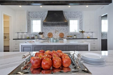 Inspiration for a huge transitional medium tone wood floor and gray floor kitchen remodel in Los Angeles with an undermount sink, recessed-panel cabinets, white cabinets, quartz countertops, gray backsplash, marble backsplash, paneled appliances, two islands and white countertops