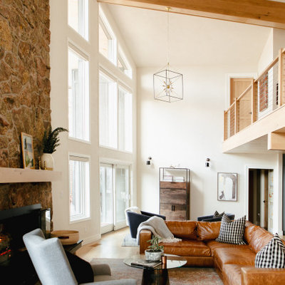 Large mountain style open concept light wood floor living room photo in Denver with white walls