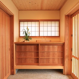 Idee per un ingresso con vestibolo etnico con pareti beige, una porta scorrevole e una porta marrone