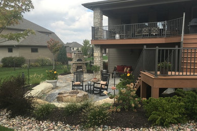 Example of a large minimalist backyard patio design in Omaha with a fire pit and no cover