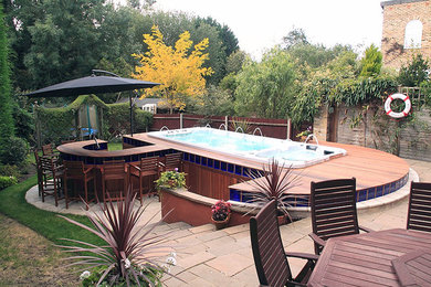 Mid-sized minimalist backyard rectangular hot tub photo in Orange County with decking