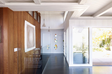 Inspiration for a midcentury hallway in San Francisco with white walls and grey floor.