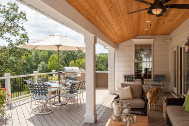 Example of a transitional backyard deck design in Cleveland with a roof extension