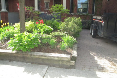 Design ideas for a traditional front yard retaining wall landscape in Ottawa.