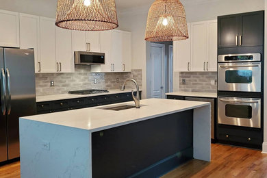 This is an example of a mid-sized contemporary l-shaped eat-in kitchen in Atlanta with an undermount sink, shaker cabinets, white cabinets, quartz benchtops, grey splashback, porcelain splashback, stainless steel appliances, with island and white benchtop.