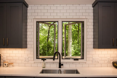 Mid-sized transitional galley medium tone wood floor and brown floor eat-in kitchen photo in Other with an undermount sink, shaker cabinets, white cabinets, solid surface countertops, white backsplash, ceramic backsplash, stainless steel appliances, a peninsula and white countertops