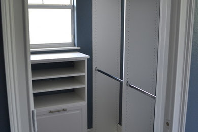 Walk-in closet - contemporary gender-neutral walk-in closet idea in Orlando with white cabinets and raised-panel cabinets