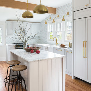 Klassische Küche in L-Form mit Landhausspüle, Schrankfronten im Shaker-Stil, grauen Schränken, Küchenrückwand in Blau, schwarzen Elektrogeräten und braunem Holzboden in Seattle