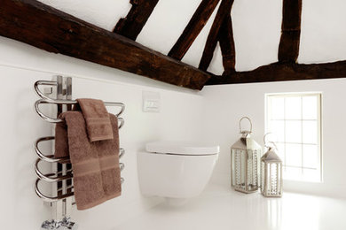 Design ideas for an expansive contemporary ensuite bathroom in Buckinghamshire with white tiles, white walls, solid surface worktops and a built-in sink.