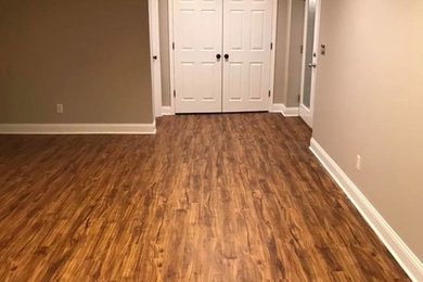 Large elegant walk-out laminate floor and brown floor basement photo in St Louis with beige walls