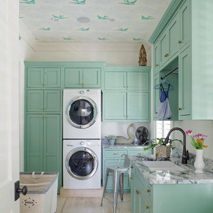 Design ideas for a classic separated utility room in Atlanta with a double-bowl sink, shaker cabinets, light hardwood flooring, a stacked washer and dryer and blue cabinets.