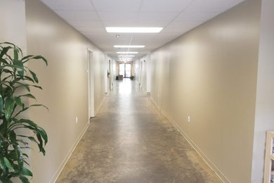 Foto de recibidores y pasillos grandes con paredes beige y suelo de cemento