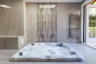 Doorless shower - huge contemporary master brown tile and glass tile porcelain tile doorless shower idea in Vancouver with beige walls, flat-panel cabinets, dark wood cabinets, a one-piece toilet, a trough sink and quartz countertops