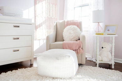 Mid-sized transitional girl dark wood floor, brown floor and wallpaper nursery photo in New York with pink walls