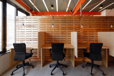 Diseño de despacho urbano con suelo de cemento y escritorio empotrado