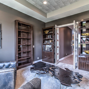 Inspiration för mellanstora klassiska hemmabibliotek, med bruna väggar och heltäckningsmatta