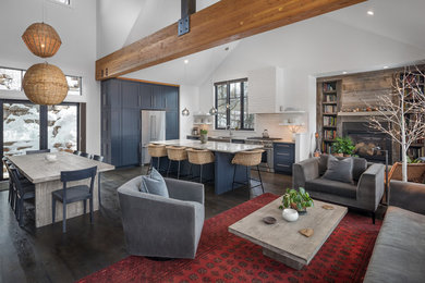Example of a mountain style open concept dark wood floor and brown floor living room design in Albuquerque with white walls and a standard fireplace