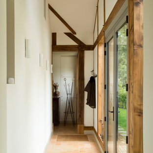 Inspiration för en mellanstor vintage hall, med klinkergolv i terrakotta och beige väggar