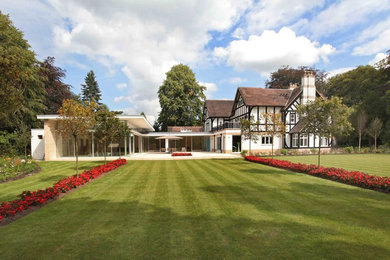 This is an example of a large and white contemporary house exterior in Other with three floors and a pitched roof.