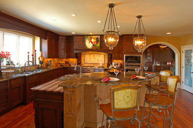 Enclosed kitchen - large traditional l-shaped dark wood floor enclosed kitchen idea in Cincinnati with a double-bowl sink, raised-panel cabinets, dark wood cabinets, granite countertops, beige backsplash, cement tile backsplash, stainless steel appliances and an island