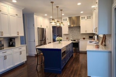 Open concept kitchen - large coastal u-shaped dark wood floor and brown floor open concept kitchen idea in Boston with an undermount sink, recessed-panel cabinets, white cabinets, white backsplash, subway tile backsplash, stainless steel appliances, an island and yellow countertops