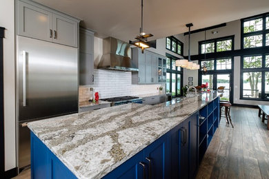 Example of a large cottage chic galley ceramic tile and multicolored floor eat-in kitchen design in Other with an undermount sink, recessed-panel cabinets, blue cabinets, quartz countertops, white backsplash, subway tile backsplash, stainless steel appliances and an island