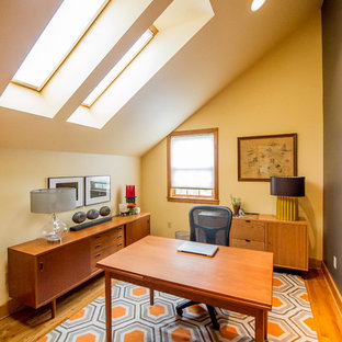 Inspiration for a medium sized modern home office and library in Boston with yellow walls, medium hardwood flooring, no fireplace and a freestanding desk.