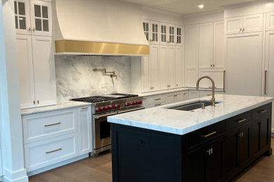 Example of a large transitional light wood floor and brown floor kitchen design in Philadelphia with shaker cabinets, white cabinets, marble countertops, white backsplash, marble backsplash and white countertops