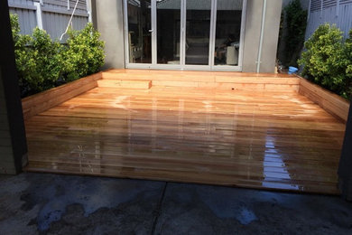 Inspiration for a contemporary backyard full sun formal garden in Melbourne with decking.