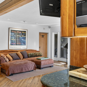 Open Midcentury Living Room Beside Cherry Cabinets & Granite Counters