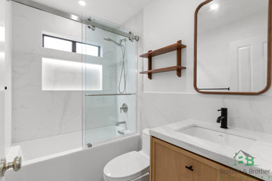 Bathroom - mid-sized modern kids' white tile and ceramic tile single-sink bathroom idea in San Francisco with shaker cabinets, brown cabinets, a one-piece toilet, a drop-in sink, marble countertops, white countertops and a built-in vanity