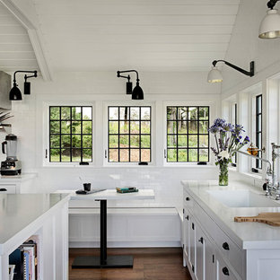 Imagen de cocina campestre con armarios estilo shaker, puertas de armario blancas, salpicadero blanco, salpicadero de azulejos tipo metro y suelo de madera oscura