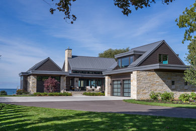 Trendy beige two-story stone house exterior photo in Grand Rapids with a metal roof