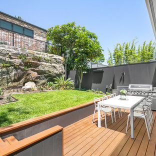Design ideas for a contemporary backyard and ground level deck in Sydney with an awning.
