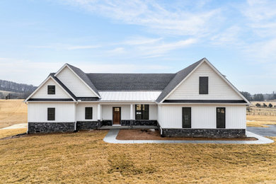 Example of a mid-sized country white one-story vinyl and board and batten exterior home design in Other with a mixed material roof and a black roof