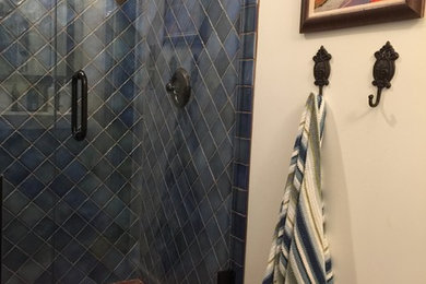 Inspiration for a mid-sized transitional 3/4 bathroom in Atlanta with an alcove shower, a two-piece toilet, blue tile, ceramic tile, beige walls and porcelain floors.