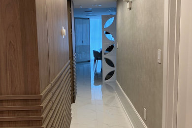 Inspiration for a small contemporary ceramic tile, beige floor and wallpaper hallway remodel in Miami with gray walls
