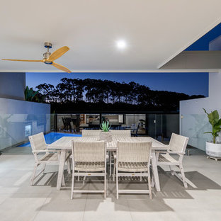 This is an example of a small contemporary backyard patio in Sunshine Coast with concrete pavers and a roof extension.