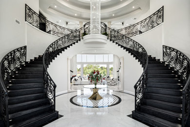 Staircase - huge modern wooden curved metal railing staircase idea in Phoenix with wooden risers
