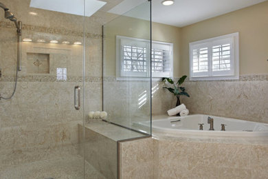 This is an example of a large traditional master bathroom in New Orleans with a corner tub, a corner shower, beige tile, porcelain tile, beige walls and a hinged shower door.