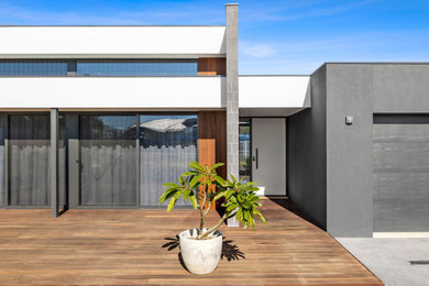 Diseño de fachada de casa gris y gris grande de una planta con revestimientos combinados, tejado plano y tejado de metal