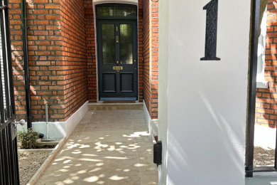 Inspiration for a modern entrance in London with white walls and brick walls.