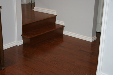 Example of a mid-sized transitional dark wood floor and brown floor hallway design in Calgary with gray walls