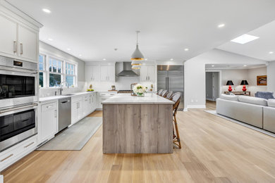 Transitional kitchen photo in New York with an undermount sink, flat-panel cabinets, quartz countertops, subway tile backsplash, stainless steel appliances and an island