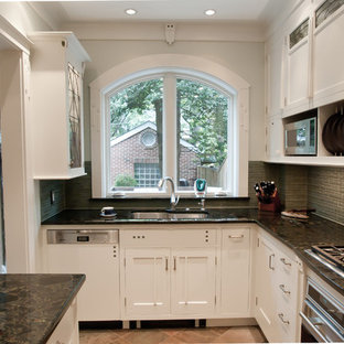 Inspiration för små amerikanska kök, med en undermonterad diskho, släta luckor, vita skåp, granitbänkskiva, grönt stänkskydd, stänkskydd i glaskakel, integrerade vitvaror och skiffergolv