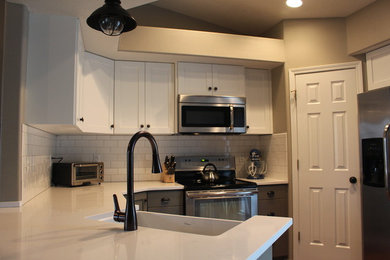 Eat-in kitchen - small cottage u-shaped medium tone wood floor eat-in kitchen idea in Boise with a farmhouse sink, shaker cabinets, white cabinets, quartzite countertops, white backsplash, subway tile backsplash, stainless steel appliances and no island