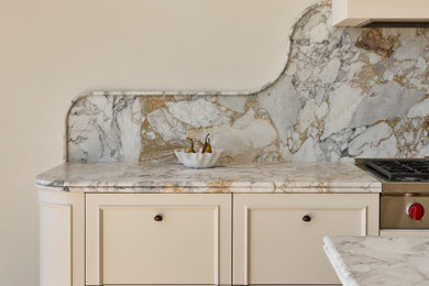 Expansive mediterranean l-shaped kitchen pantry in Sydney with an undermount sink, beaded inset cabinets, beige cabinets, marble benchtops, grey splashback, marble splashback, stainless steel appliances, light hardwood floors, with island, brown floor and grey benchtop.