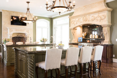 Inspiration for a huge timeless medium tone wood floor eat-in kitchen remodel in Los Angeles with raised-panel cabinets, green cabinets, stainless steel appliances, two islands, a single-bowl sink, granite countertops and green backsplash