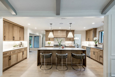 Example of a mid-sized transitional u-shaped light wood floor and beige floor eat-in kitchen design in Dallas with a drop-in sink, recessed-panel cabinets, light wood cabinets, quartz countertops, white backsplash, ceramic backsplash, stainless steel appliances, an island and multicolored countertops
