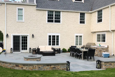 Großer, Unbedeckter Klassischer Patio hinter dem Haus mit Outdoor-Küche und Natursteinplatten in New York